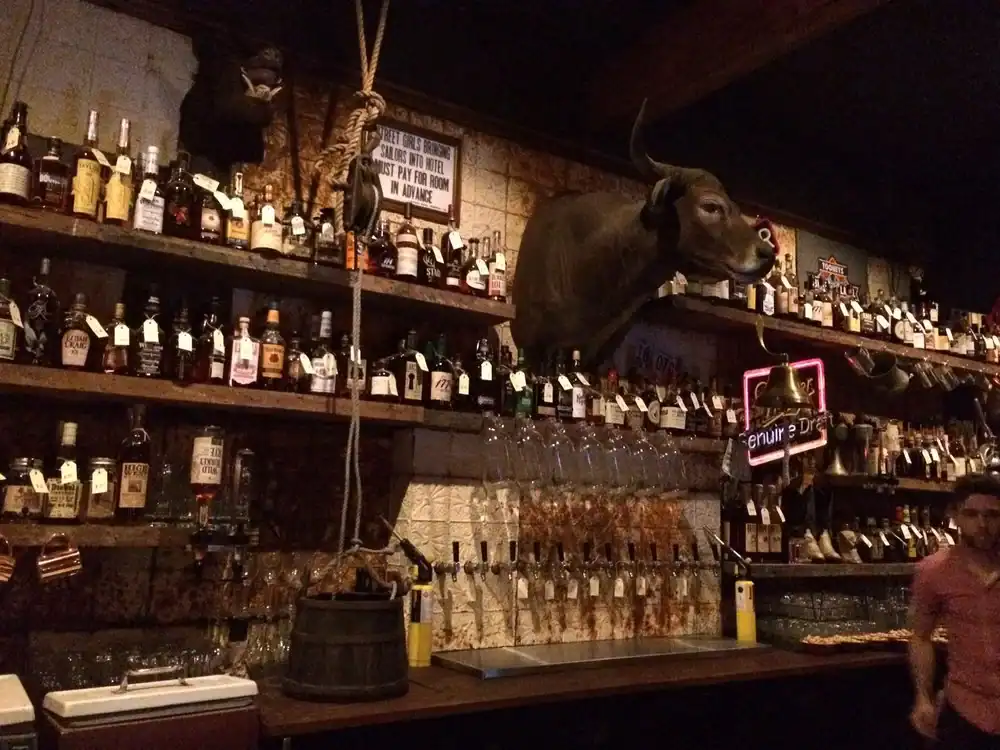Bottle display shelves with liquor bottles at a bar.