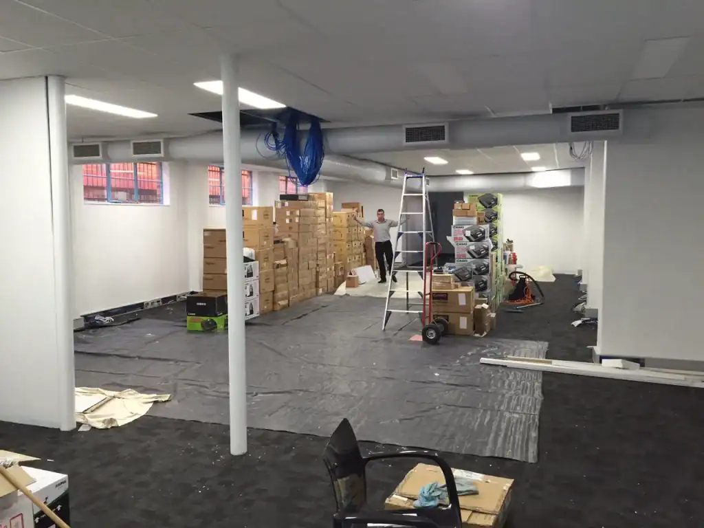 Boxes of office equipment and supplies in a warehouse setting.