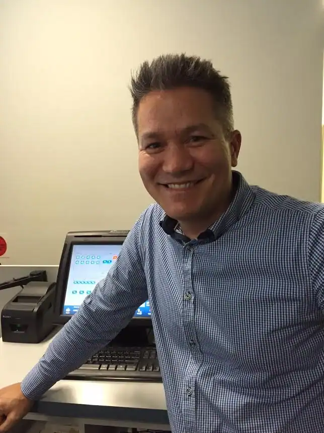 Kevin smiling at a 21st Century Business Equipment store with office technology in the background.