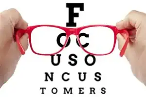 Eyeglasses with eye chart behind, optometry vision test for eye health and correction.