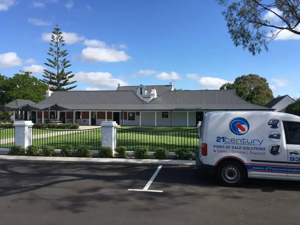 Professional business equipment delivery van parked outside a modern office building.