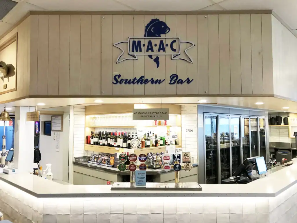 Modern bar counter with wine bottles and a point-of-sale system at a southern bar.