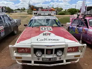 Brake repair race car front view, vintage racing vehicle with sponsor decals, 21st Century Business Equipment focus.