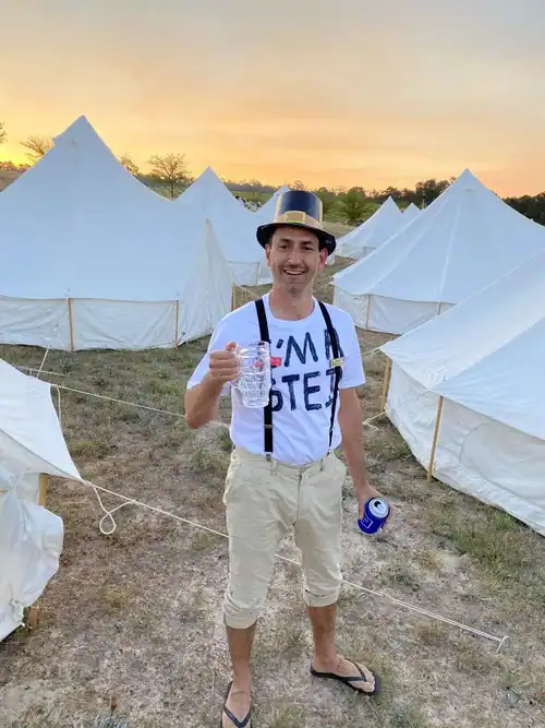 Tent camping setup at sunset with tents and outdoor gear.