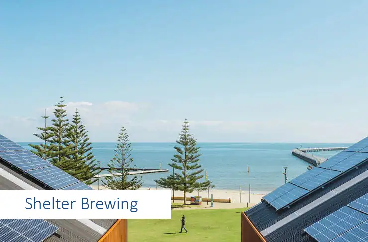 Solar panels on rooftops with ocean view in background.