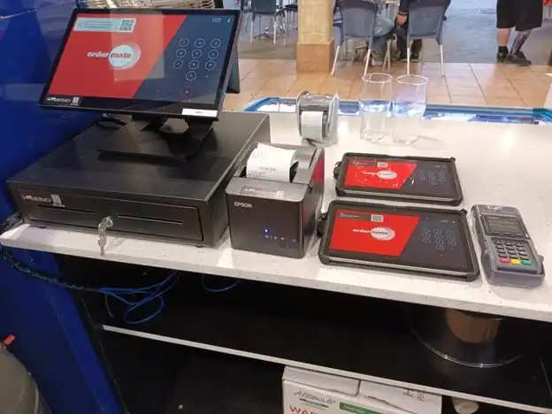 High-tech point of sale system with receipt printer, tablets, and card reader for business transactions.