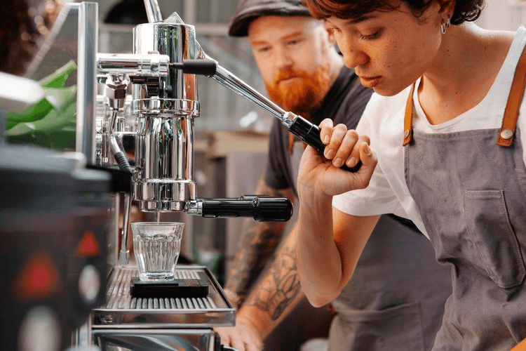 Espresso machine close-up in busy coffee shop scene.