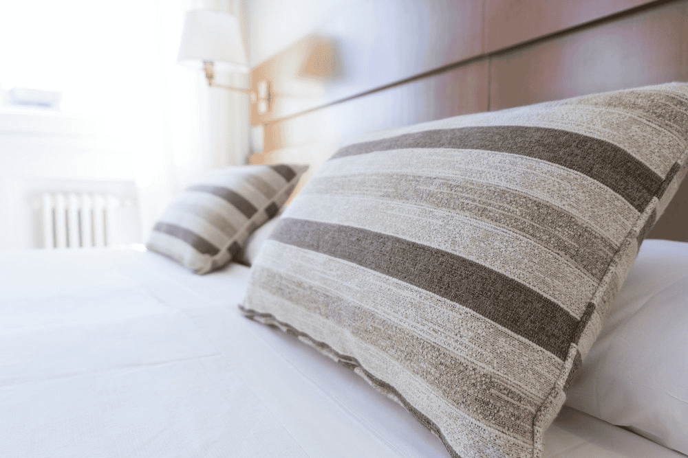 Clean hotel bedroom with striped pillows and modern decor for professional work environment.