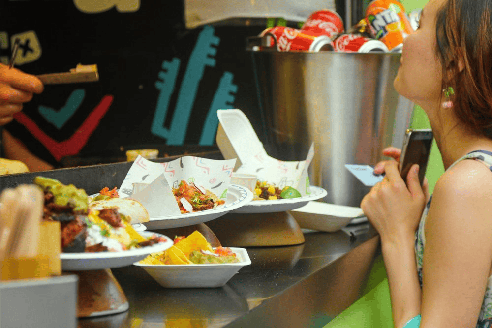 Fast food customer at counter ordering tacos and burritos.