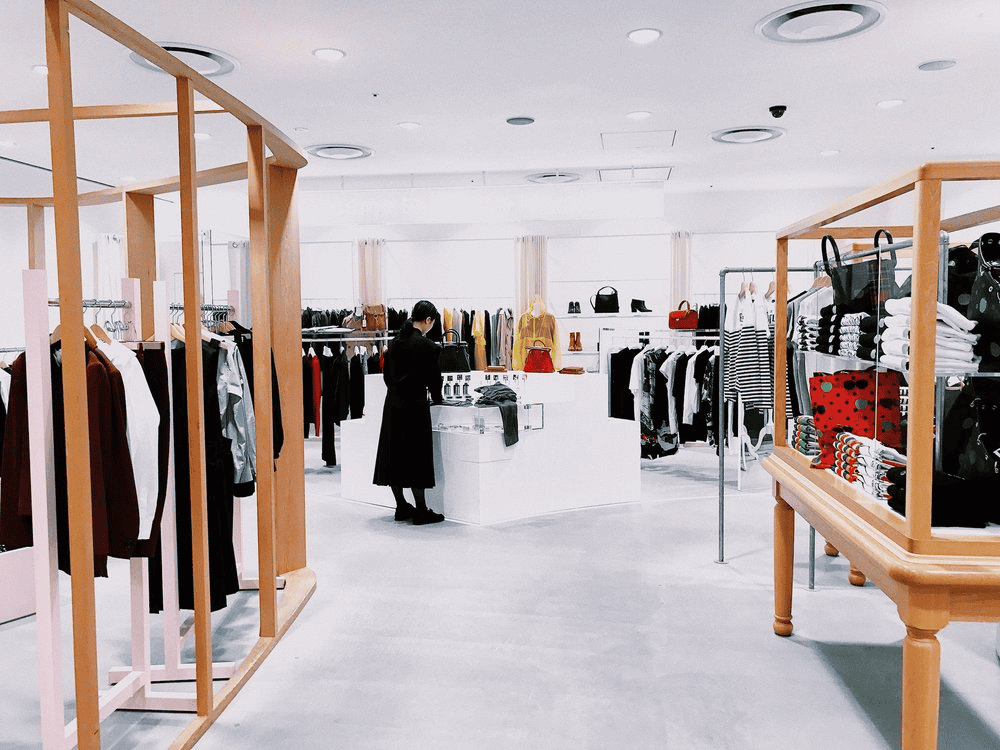 Office clothing store interior with racks of apparel and accessories.