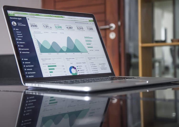 Data analytics dashboard on laptop screen, business data analysis, digital marketing metrics, modern workplace technology, business intelligence tools.