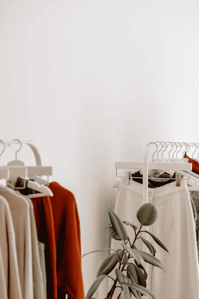 Clothing rack with various garments, indoor studio shot.