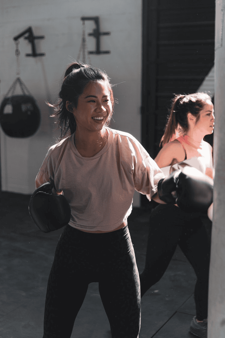 Boxing women training at gym, fitness workout, boxing gloves and punching bag, healthy active lifestyle.