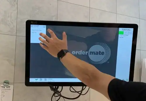 Touchscreen device being used with a hand, office setting.