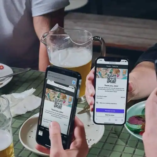 Scanning QR codes on smartphones at a social gathering for digital access or payments.
