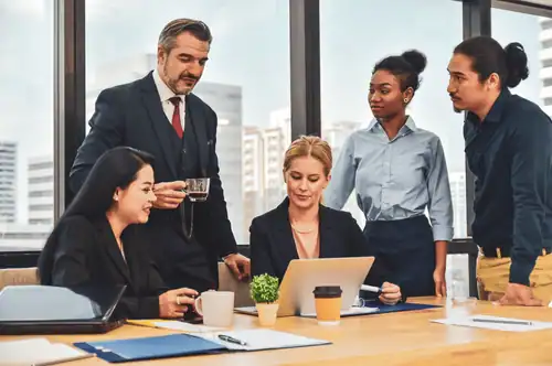 Modern business team in a corporate office discussing with a leader.