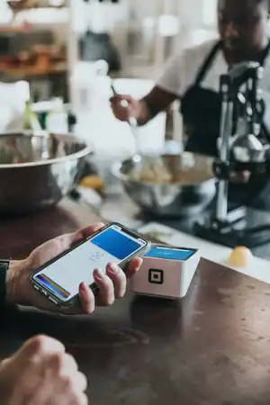 Mobile payment device being used at a cafe for quick transactions.