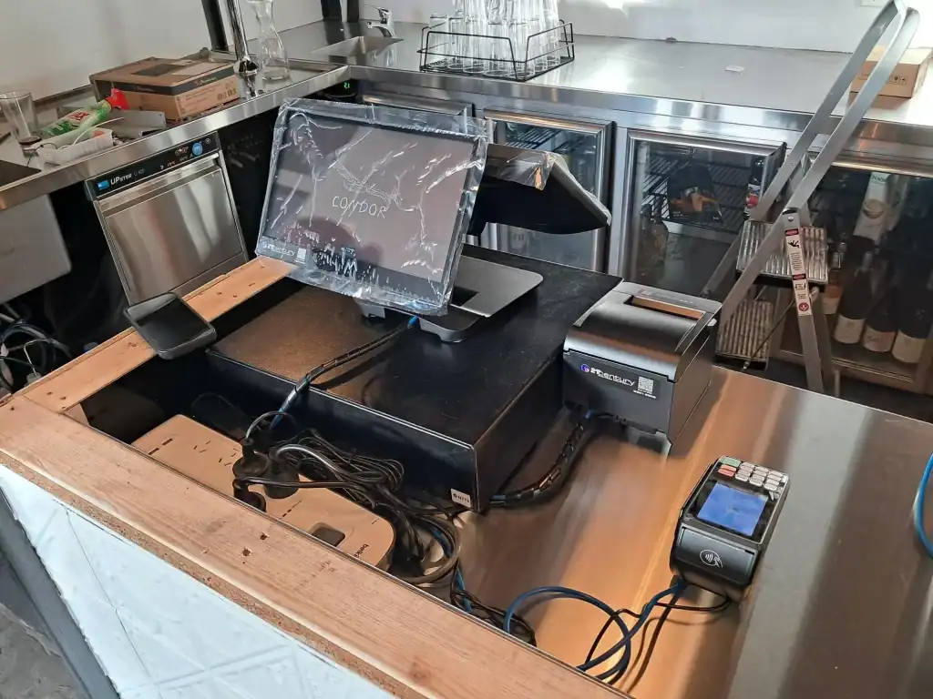 21st Century Business Equipment cash register and electronic equipment setup in a commercial kitchen or store.