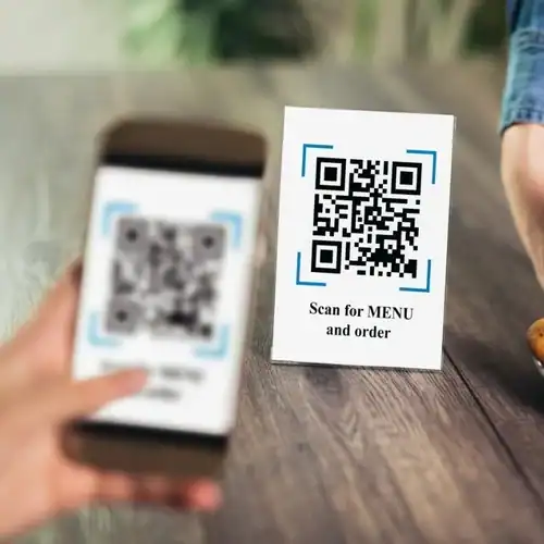 QR code on table for menu and ordering at a restaurant, smartphone scanning the code.