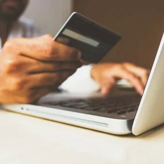 Credit card payment being processed on a laptop.