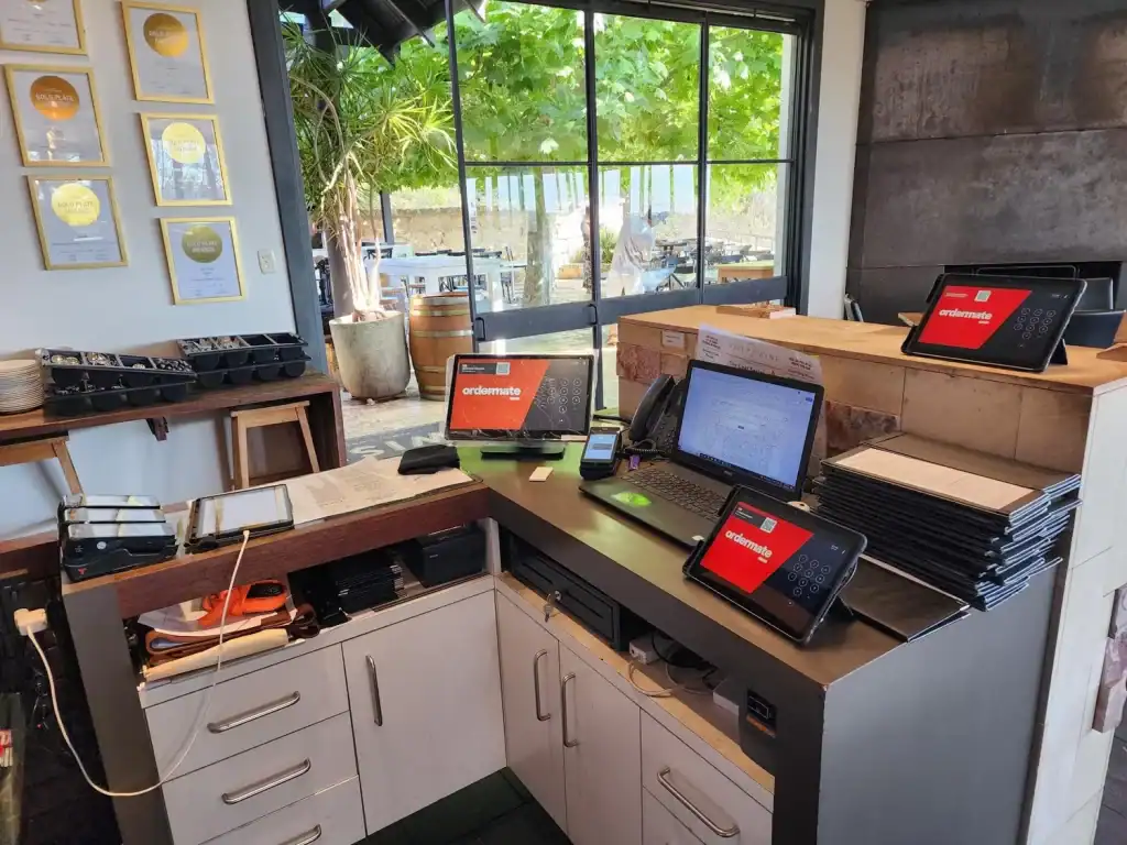 Ordermate touchscreen point of sale system on a reception desk.