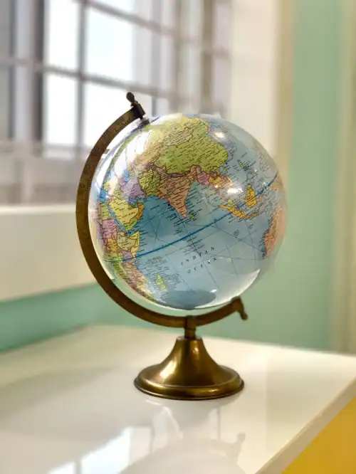 Globe on desk in bright office setting.