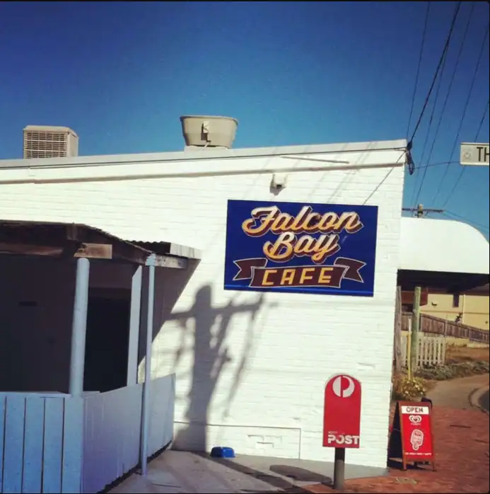 Falcon Bay Cafe storefront with vibrant signage and outdoor seating area.
