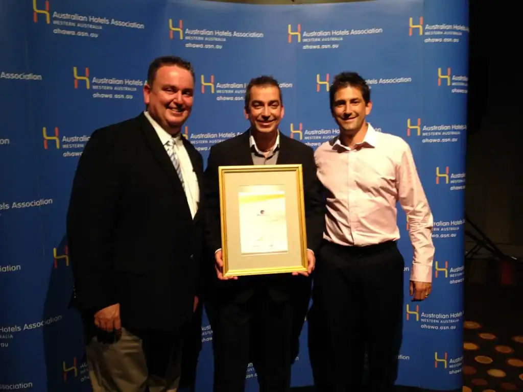 Award-winning business team celebrating achievement at Australian Hotels Association event.