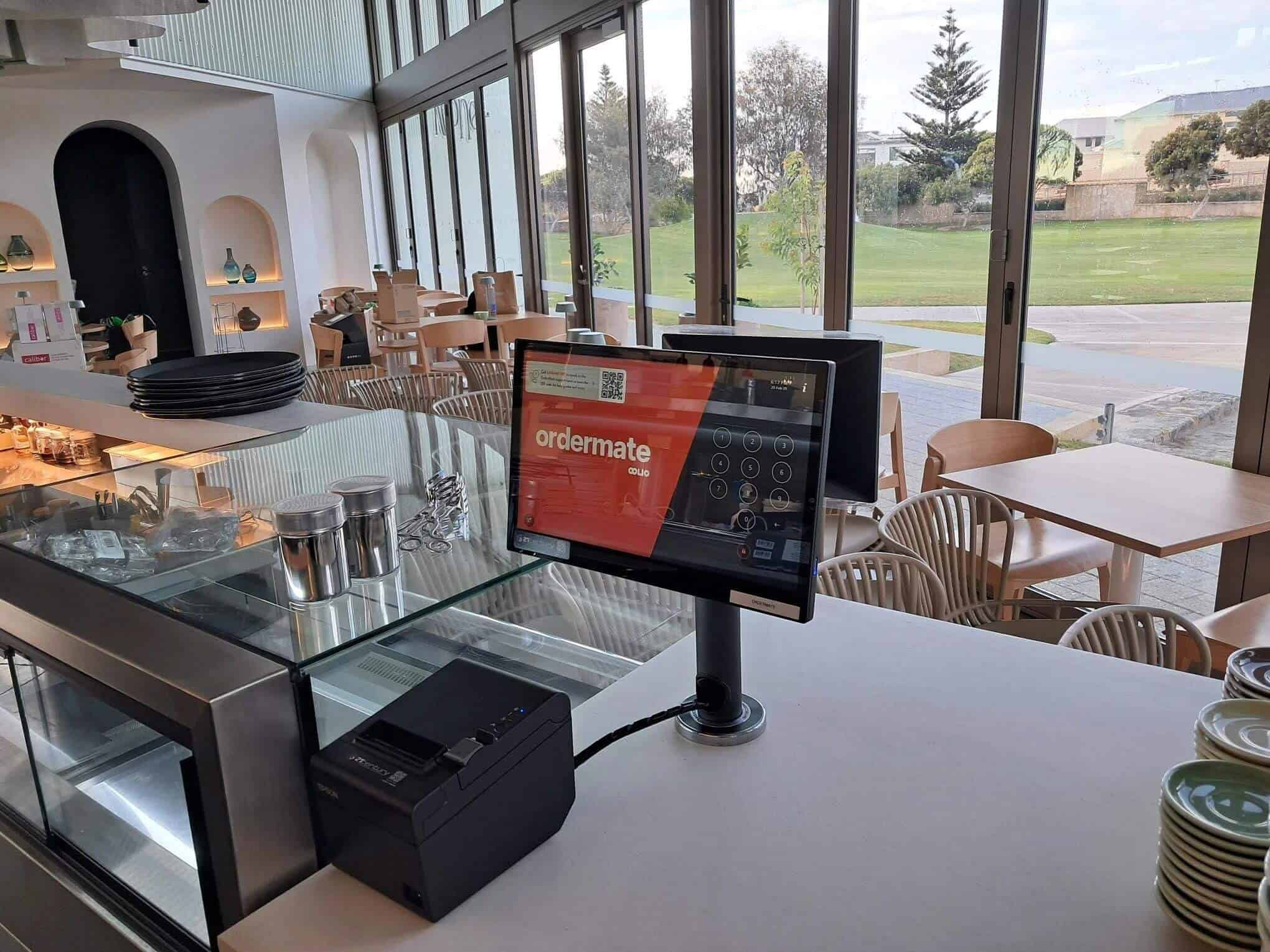 Point of sale cash register with order system and kitchen display in a modern restaurant.